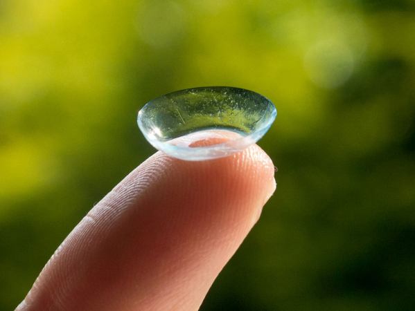 A contact lens resting on a fingertip