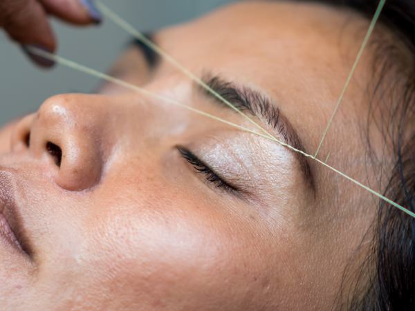 A person's eyebrows being threaded