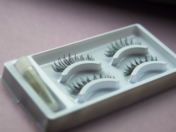 A tray containing strips of false eyelashes and glue