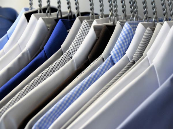 A rail of shirts in different shades of blue and white