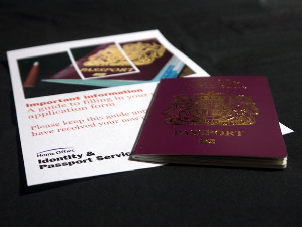 A red UK passport sat onto top the Identities and Passport Services information leaflet.