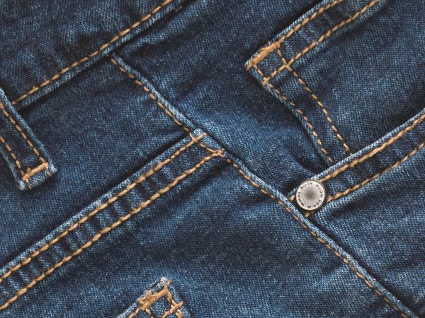A close-up photo of the waistline of blue denim jeans